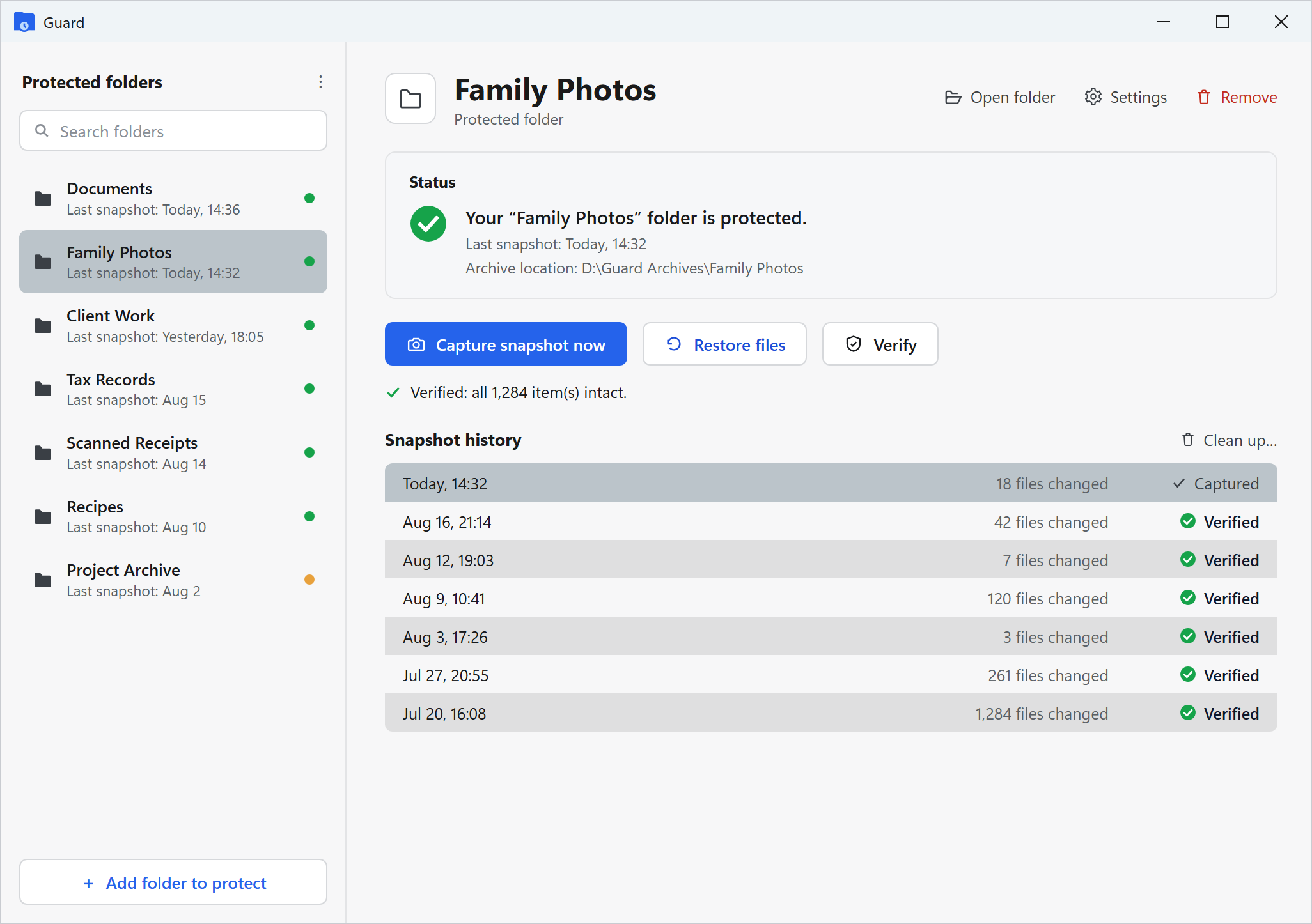 The Guard app on Windows: a sidebar of protected folders (Documents, Family Photos, Client Work, Tax Records, Scanned Receipts, Recipes, Project Archive), each with a status dot and the date of its last snapshot, and for the selected Family Photos folder its protection status, an archive location on a separate drive, a note that all 1,284 items were verified intact, and a month of snapshot history carrying Captured and Verified health badges, above Capture snapshot now, Restore files and Verify actions.